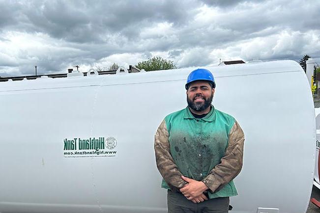 Thomas G. in front of large gas tank